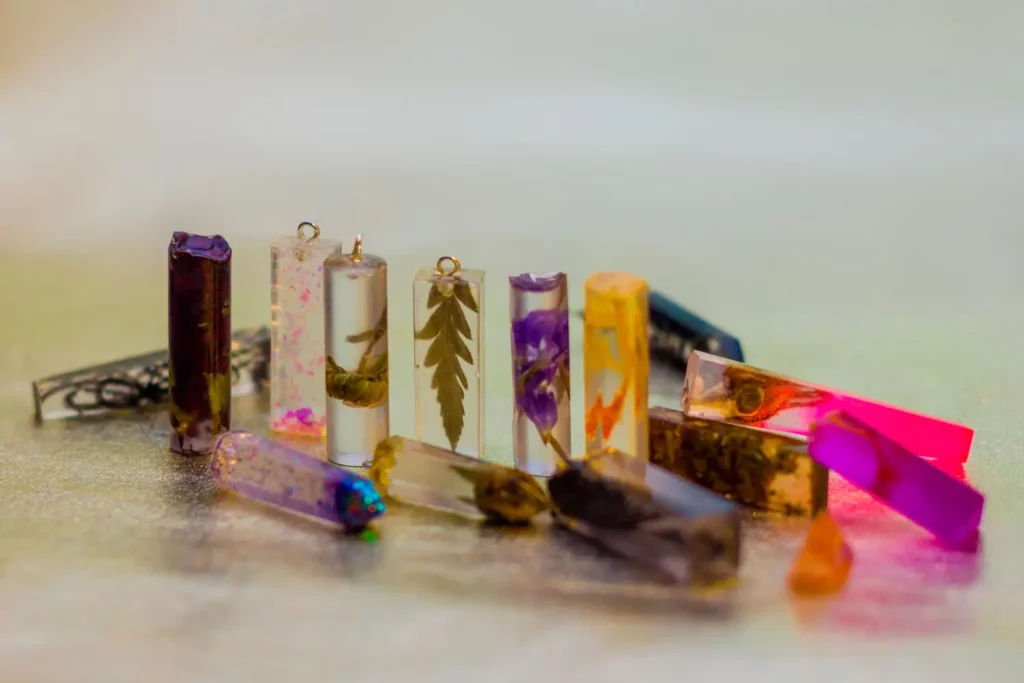Colorful resin pendants with pressed flowers and leaves.