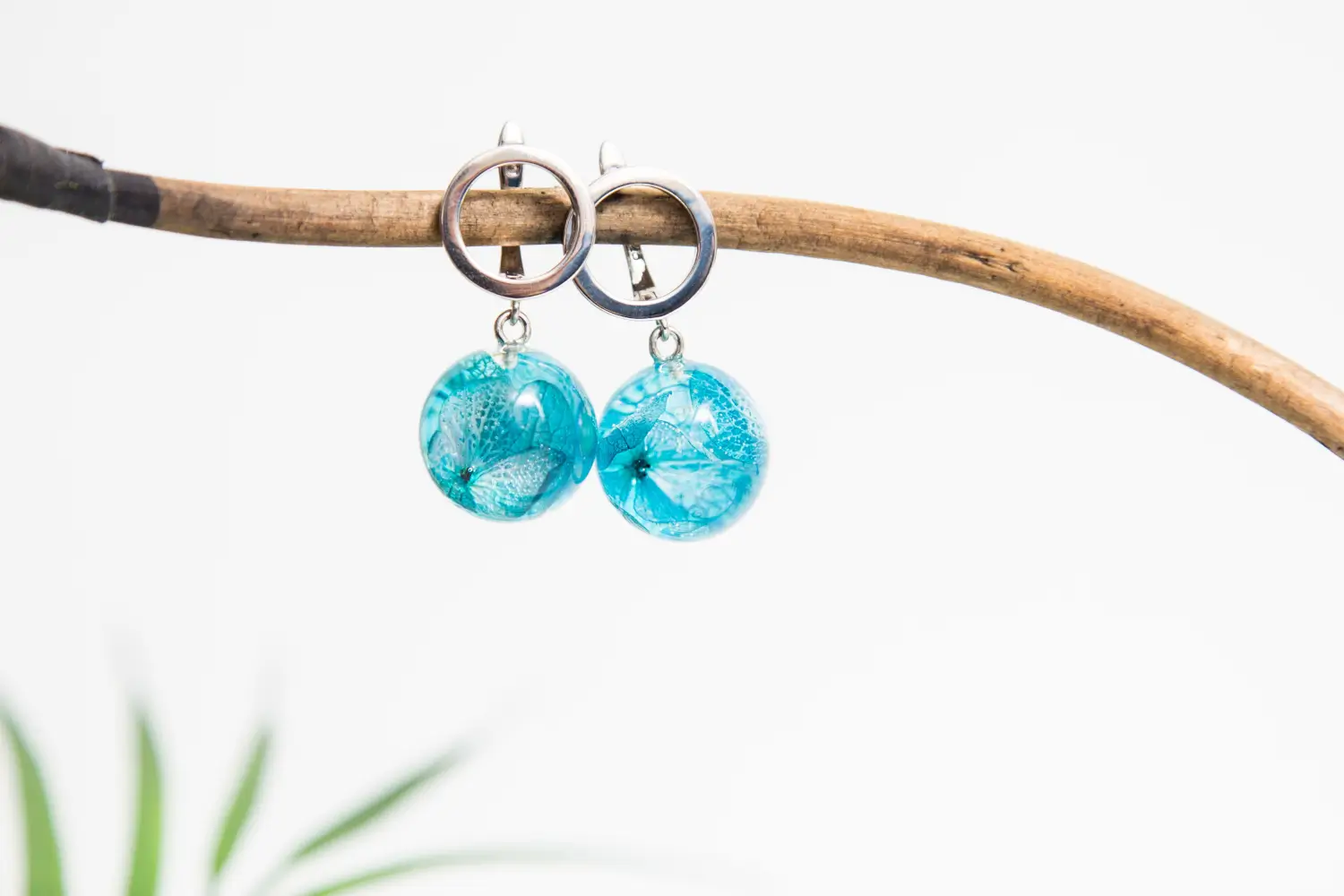 Turquoise resin earrings with flower design, silver hoops.