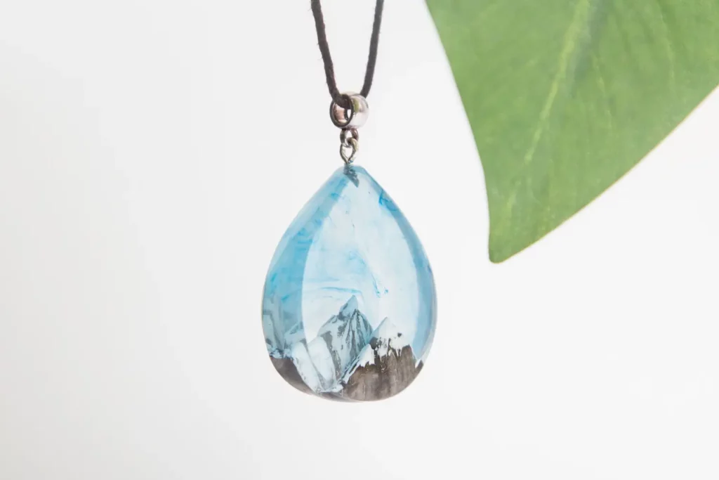 Teardrop-shaped resin pendant, mountain scene, blue, necklace.